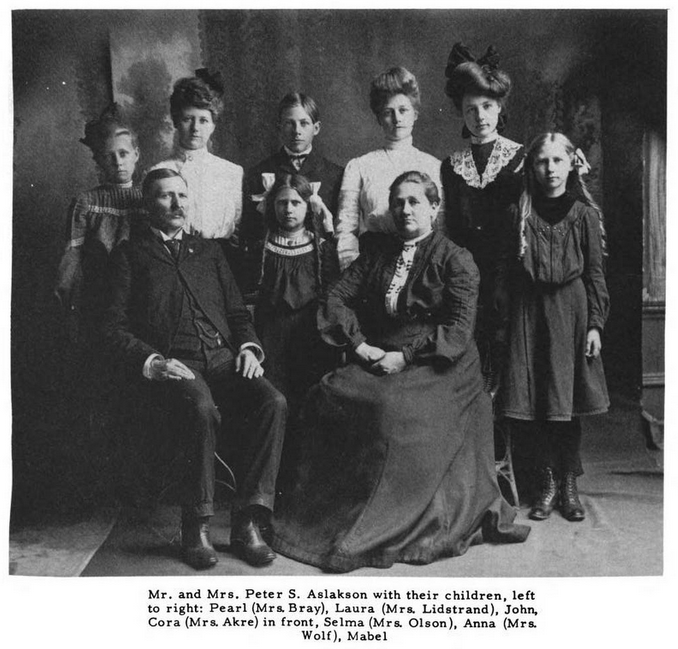 IMAGE/PHOTO: Mr. and Mrs. Peter S. Aslakson and family: Black and white photo of Mr. and Mrs. Peter S. Aslakson with their children, taken about 1900. John Aslakson, a short boy with straight hair parted in the middle, stands at the center of the back row.
